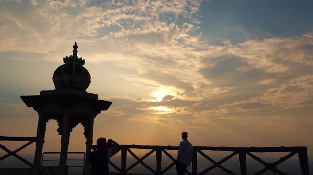 Silhouettes of people helping each other on top of a mountain at Samai Mata Mandir, Banswara, near Udaipur, Rajasthan, India.