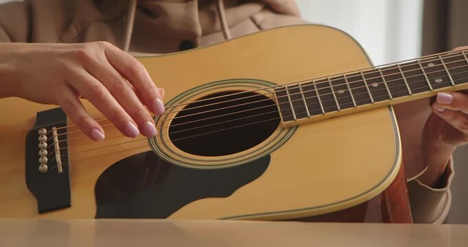 Close up of Hand Playing Acoustic Guitar Strings