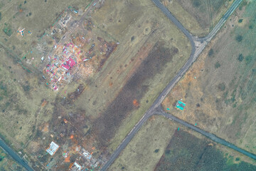 Debris scattered across a residential area and public spaces showing indiscriminate shelling damage and war aftermath aerial view