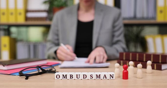 Office work showcase highlighting an ombudsman reviewing cases with colorful figures in an organized environment