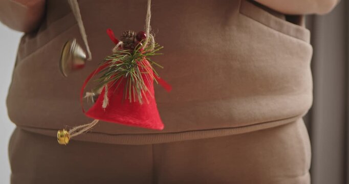 Woman ringing festive Christmas bell with jingle ornaments