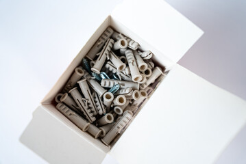 Fototapeta premium Open box filled with assorted wall plugs and screws on a white background. Construction and home repair supplies, hardware tools. High quality photo