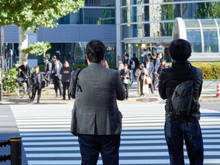 Obraz premium 都心の街の交差点で信号待ちのビジネスマンの姿