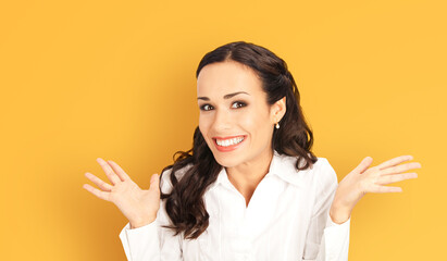 Portrait image - happy shocked businesswoman with expressive wide open eyes, mouth, isolate orange yellow background. Business woman in white shirt raise hands gesturing pointing astonishment emotion