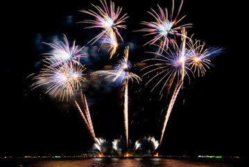 Amazing beautiful colorful firework display over sea on celebration night. Fireworks show for happy new year	