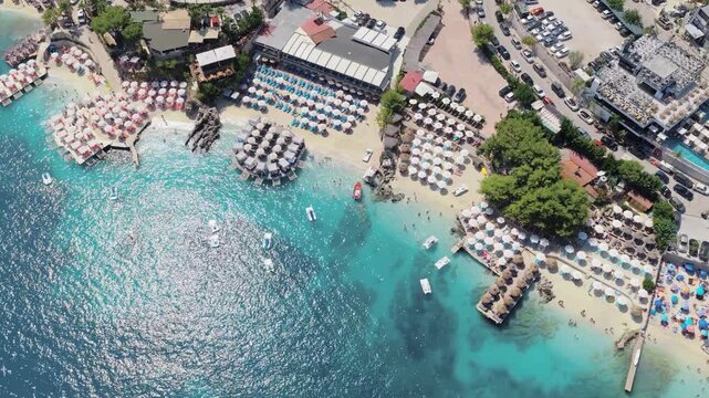 Aerial view of the vibrant beach with turquoise water and white umbrellas, creating a stunning contrast, Ksamil, Vlore County, Albania.