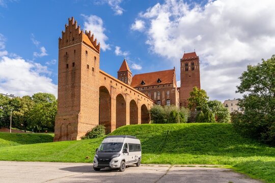 view of Kwidzyn Castle and its landmark five-arcade dansker and a camper van in the foreground