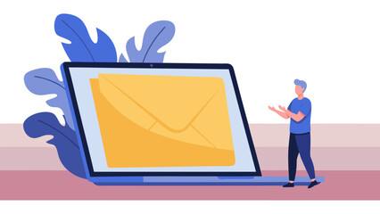 A man stands next to a laptop displaying a large yellow envelope on its screen.