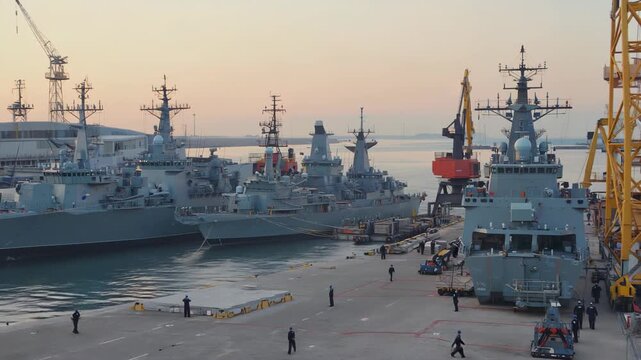 Aerial view of a naval fleet led by an aircraft carrier with aircraft, demonstrating military power and defense capability at sea.