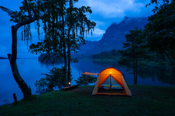 Night camping adventure with a cozy tent lit under the starry sky in a summer forest