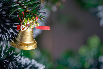 Golden Bell with "Merry Christmas" Ornament Hanging on Festive Tree, with Copy Space