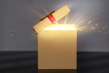 Magical Unboxing: Open Gift Box with Exploding Golden Light and Sparkles on Dark Background, Christmas/New Year Theme