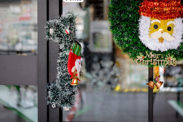 Santa Claus Wreath and Christmas Stocking Hanging on Glass Door, Festive Holiday Season Decoration and Greeting.