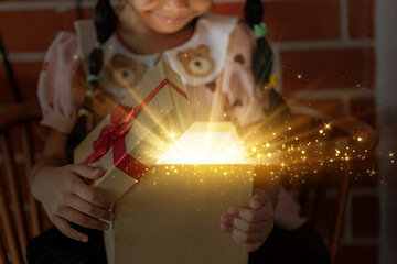 Excited Child Opening a Magical Gift Box with Golden Light and Sparkling Stars, Symbolizing Christmas Joy and Wonder.