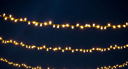 Image with blurred yellow string light against a dark blue starry background, creating an atmosphere of celebration, suitable for festive occasion