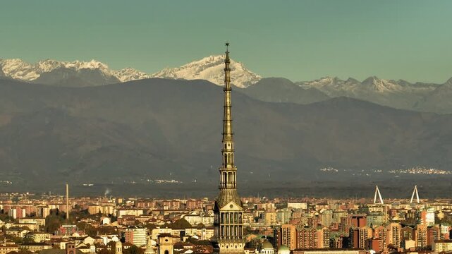 Aerial view of Mole Antonelliana towering over the city with snowy mountain ranges in the background, Turin, Piedmont, Italy.
