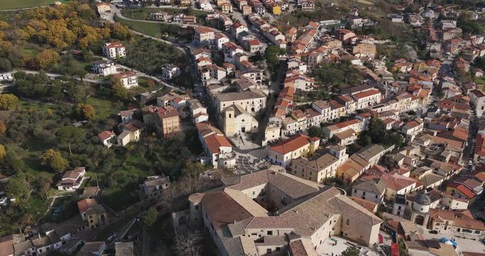 Aerial view of buildings with orange roofs intermingling with greenery, and roads cutting through the landscape, Gesualdo, Irpinia, Italy.