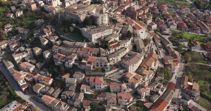 Aerial view of Gesualdo town, a tapestry of terracotta roofs cascading down the hillside towards the historic castle, Gesualdo, Irpinia, Italy.