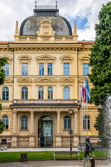 Facade of the Rectorate of the University of Maribor, historic academic building surrounded by a green park on Slomskov Trg square, Maribor city center, Slovenia.