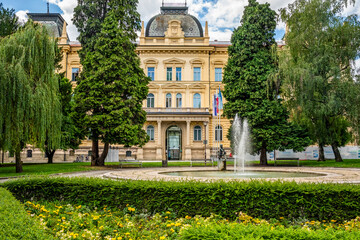 Facade of the Rectorate of the University of Maribor, historic academic building surrounded by a green park on Slomskov Trg square, Maribor city center, Slovenia.