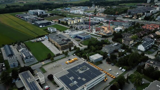 Aerial view of buildings interspersed with green trees and fields, creating an interesting pattern of urban development, Gland, Vaud, Switzerland.