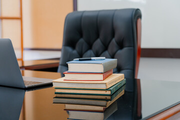 Books were arranged on the executive's desk, with a laptop beside it.