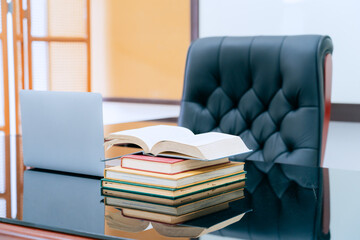 Books were arranged on the executive's desk, with a laptop beside it.