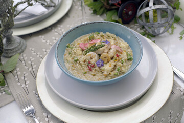 A delicious plate of risotto with shrimp, finely decorated on a decorated table