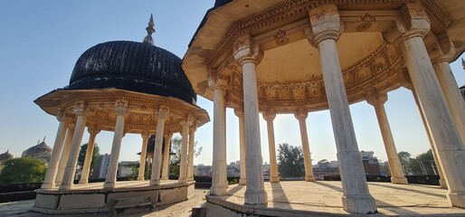 Traditional Rajasthani Cenotaphs  and Tall Columns, Showcasing Intricate Architectural Heritage and Weathered Stone Structures in Mandawa, Rajasthan, India