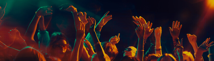 Dancing crowd silhouettes under dramatic concert lighting. Concept of shared emotions, rhythmic...