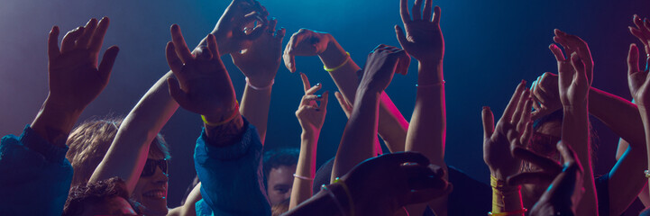 Group of young people dancing closely at night event. Concept of New Year social celebration,...