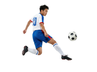 Soccer player kicking ball in mid air isolated on white background
