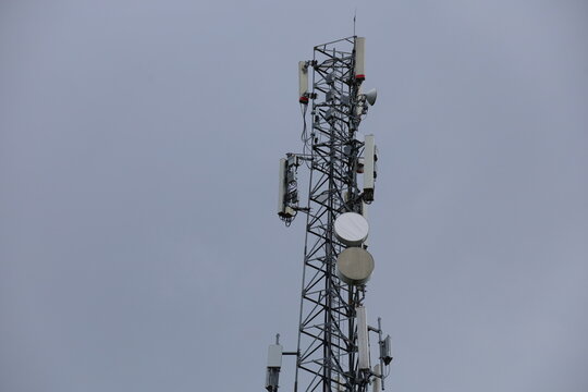 Wireless communication technology uses a steel tower with a cell phone antenna for radio signal transmission to the mobile network in the blue sky