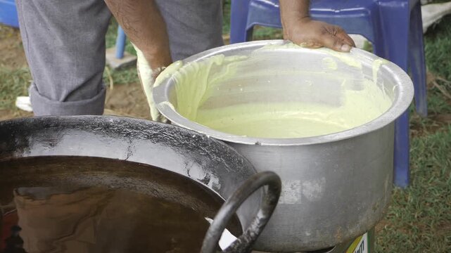 Hand Stirring Green Liquid in Pot - Cooking Method