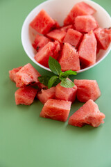 watermelon cubes on green background with natural texture