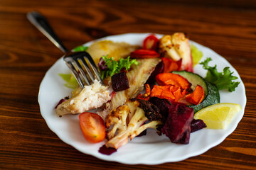 Fresh baked fish served with vegetables and lemon