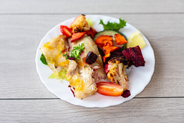 Oven baked fish fillet with vegetables and lemon garnish