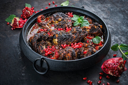 Traditional authentic Persian khoresh fesenjan - chicken stew with walnut and pomegranate sauce served as close-up in a cast iron pot