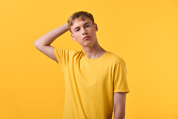 Yellow shirt, young man, yellow background, casual pose, studio shot, fashion, relaxed expression with minimal styling, bright color harmony and textured fabric detailing