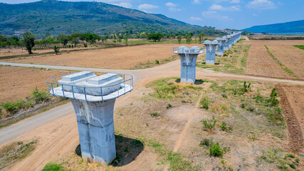 The concrete pillars/piers for the high-speed rail track are under construction at the unfinished construction site.