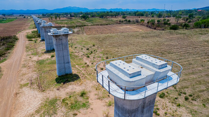 The concrete pillars/piers for the high-speed rail track are under construction at the unfinished construction site.