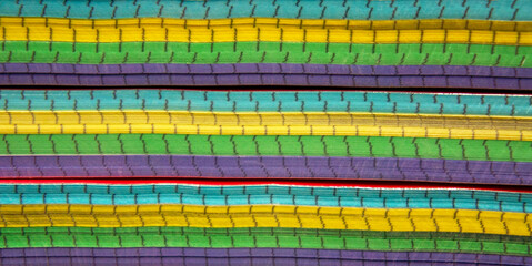 Stacked paper notebooks with colorful edges, creating a vibrant abstract background from layered pages