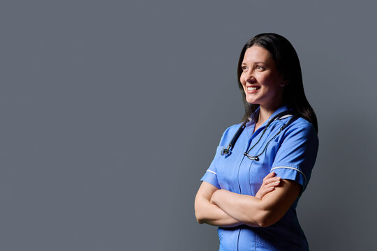 Profile portrait of confident middle-aged woman doctor, nurse on grey background
