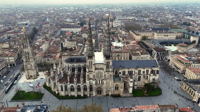 Drone flyover of Bordeaux Saint-Andre Cathedral and Pey Berland Tower revealing busy square
