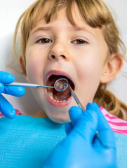 A child at the dentist gets his teeth treated. Selective focus.