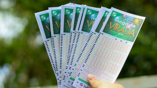 V&aacute;rias cartelas da Mega Sena da Virada na m&atilde;o simbolizam apostas em massa, tradi&ccedil;&atilde;o nacional e a busca pelo pr&ecirc;mio recorde do sorteio especial. S&atilde;o Paulo SP em 13 dez 2025