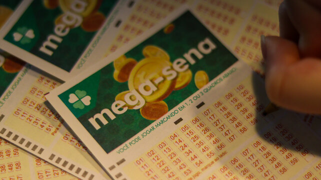 Volantes da Mega Sena em m&atilde;os evidenciam o h&aacute;bito de apostar, a esperan&ccedil;a de ganho financeiro e a tradi&ccedil;&atilde;o das loterias oficiais no Brasil. S&atilde;o Paulo SP em 14 dez 25