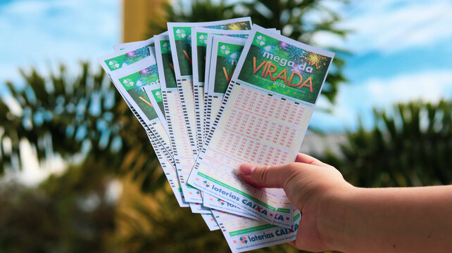 Pessoa segurando v&aacute;rios volantes da Mega da Virada simboliza apostas, expectativa de pr&ecirc;mio milion&aacute;rio e o h&aacute;bito popular das loterias no per&iacute;odo de fim de ano. S&atilde;o Paulo SP em 14 dez 25