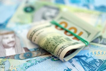 Fototapeta premium Bahraini dinar currency money bills and bunch of us dollar banknotes close up. The concept of economics and currency exchange