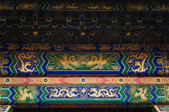 View of intricate details in blue, red, gold, and black with dragon and phoenix motifs adorn a traditional Chinese building, Beijing, Beijing, China. - Powered by Adobe